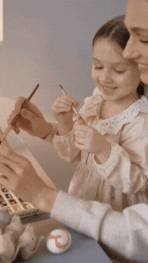 Adulto y niña pintando juntas en familia